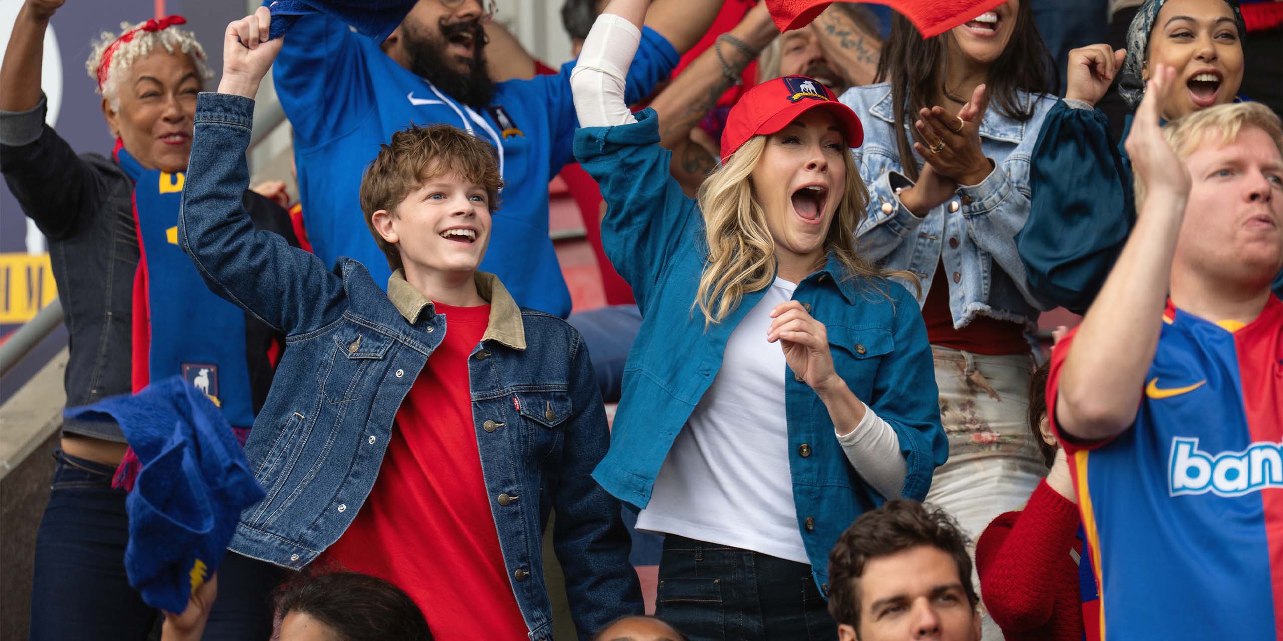 Michelle et Henry, l’ex-femme et le fils de Ted Lasso, célèbrent dans les tribunes pendant le match de l’équipe féminine de l’AFC Richmond.