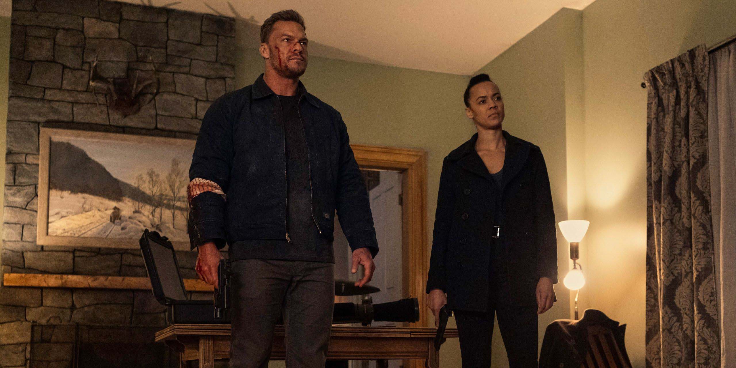 Reacher (Alan Ritchson) et Neagley (Maria Sten) debout ensemble à l'intérieur d'une maison dans Reacher
