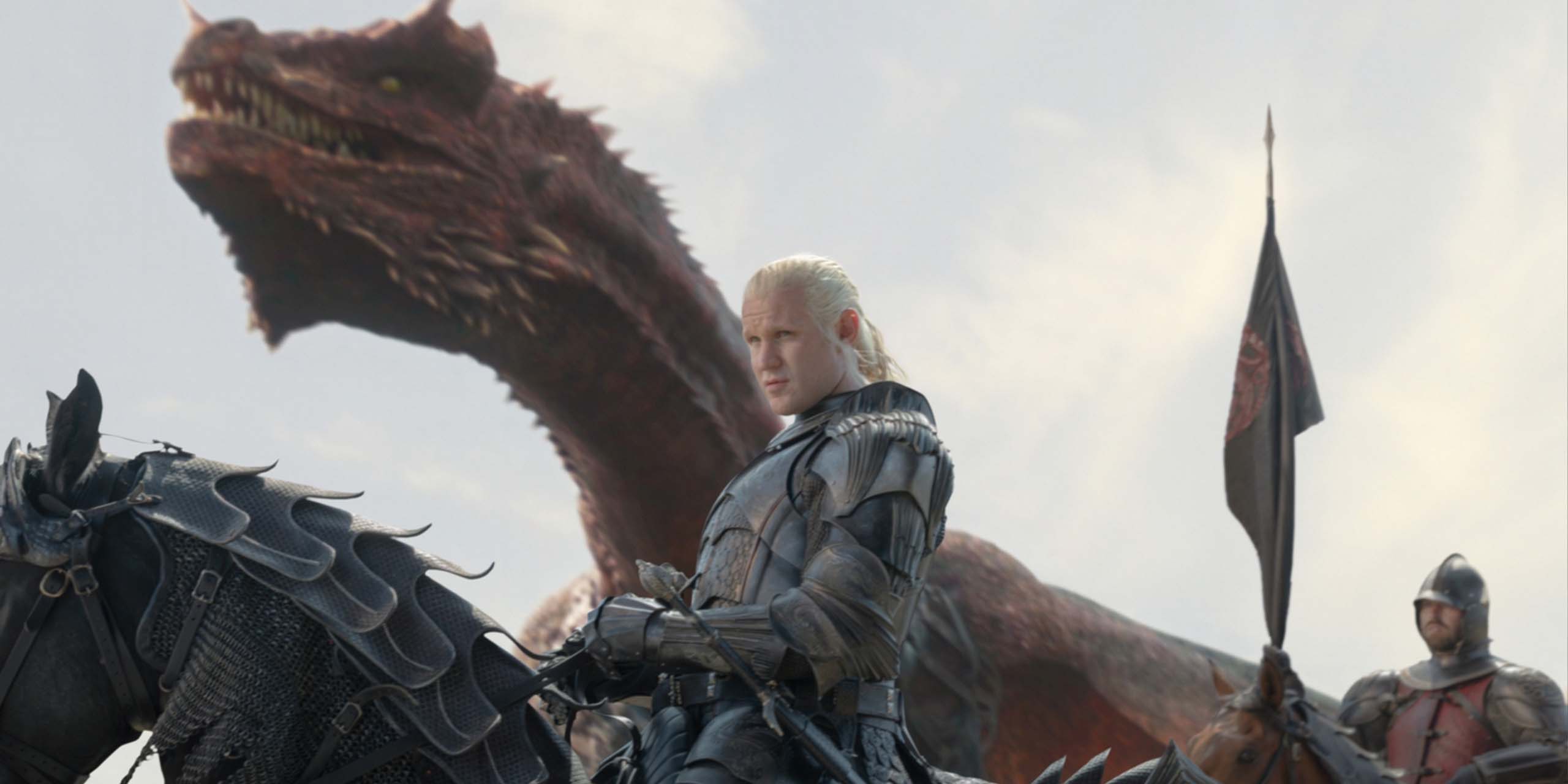 Daemon (Matt Smith) en armure sur son cheval, suivi par son dragon en fond, dans le final de la saison 3 d'House of the Dragon.