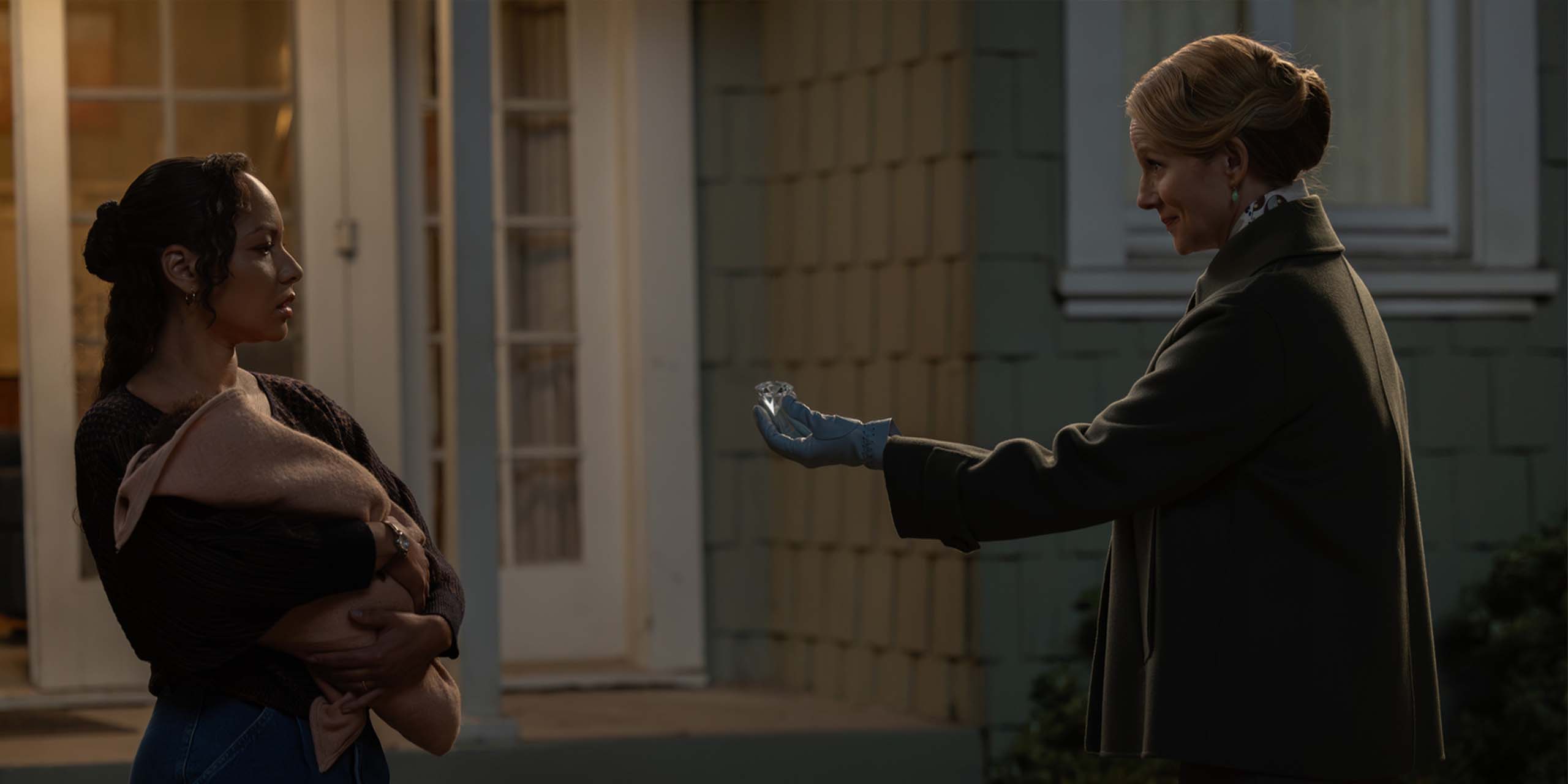 Le Gardien de l'univers (Laura Linney) serrant la main de John Stewart (Aaron Pierre) tendant un diamant à la mère de John Stewart, Bernadette (Jasmine Cephas Jones) dans Lanterns,
