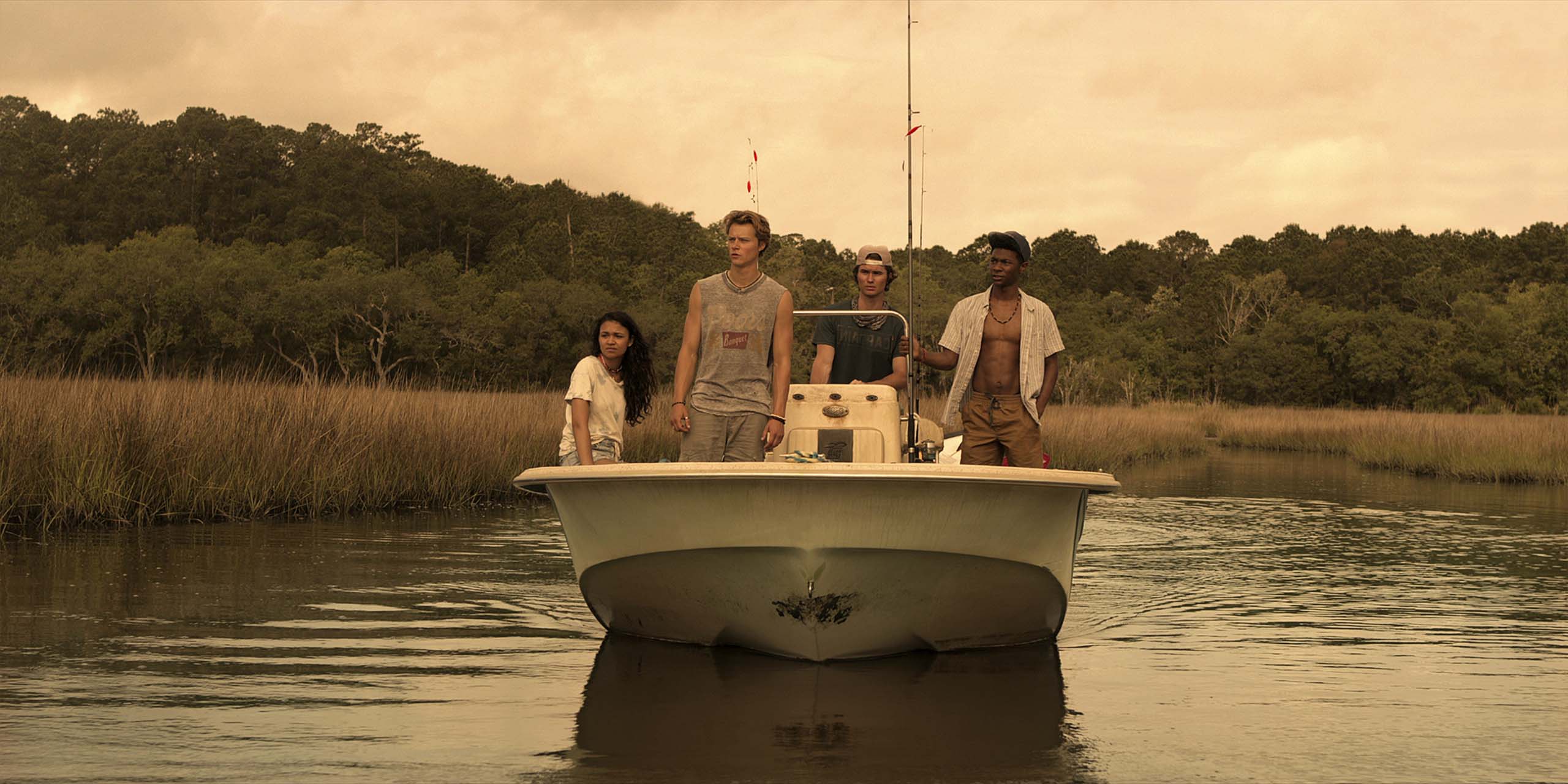 Quatre personnes sur un bateau, dans Kildare, le spin-off de la série Outer Banks, sur Netflix.