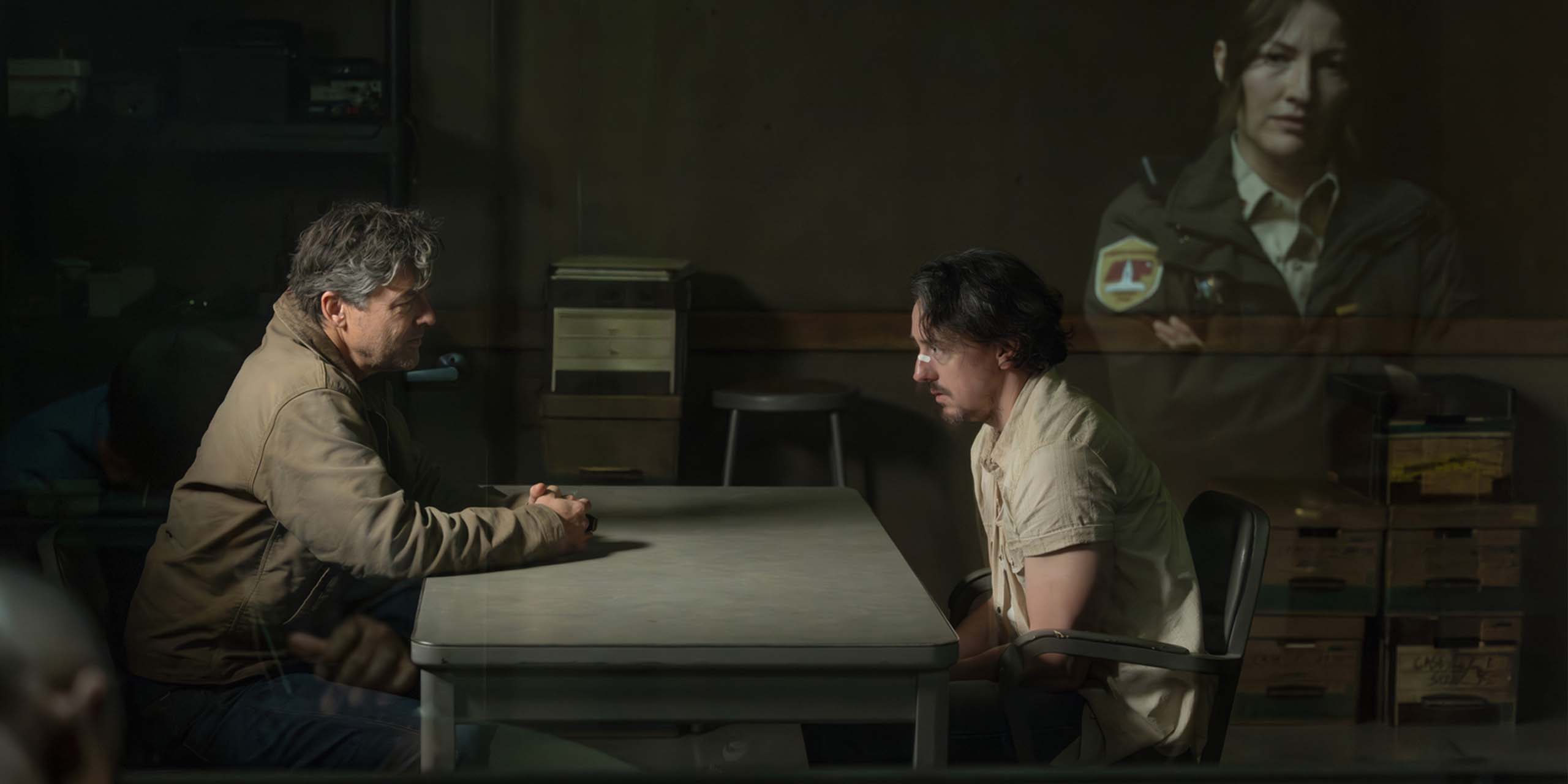 Hal Jordan (Kyle Chandler) interrogeant Waylon Sanders (Chris Coy), tandis que Kerry (Kelly MacDonald) les observe, dans Lanterns.