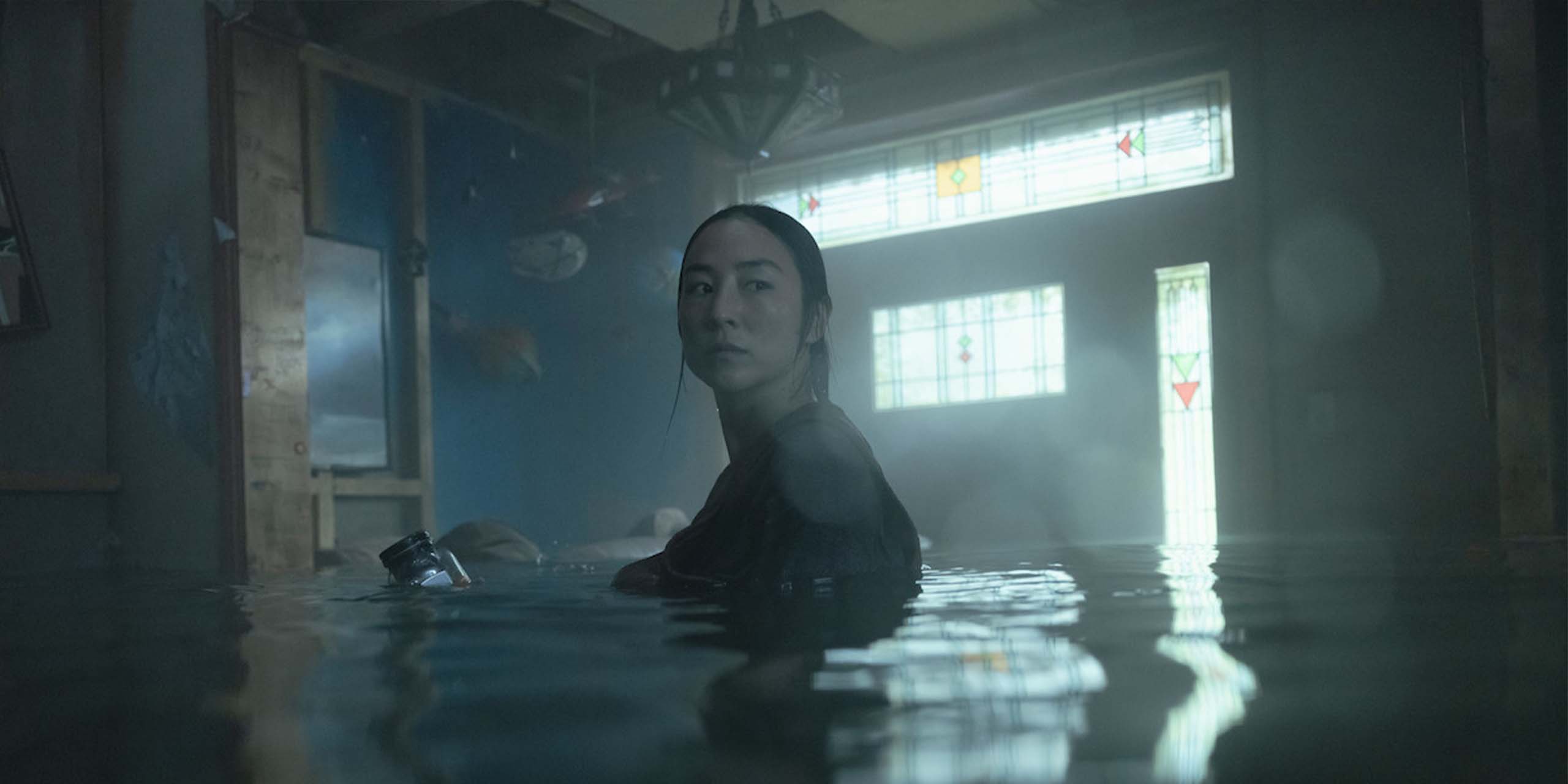 Ann Delgado (Greta Lee) dans une pièce inondée dans Le Dernier Refuge (The Last House).