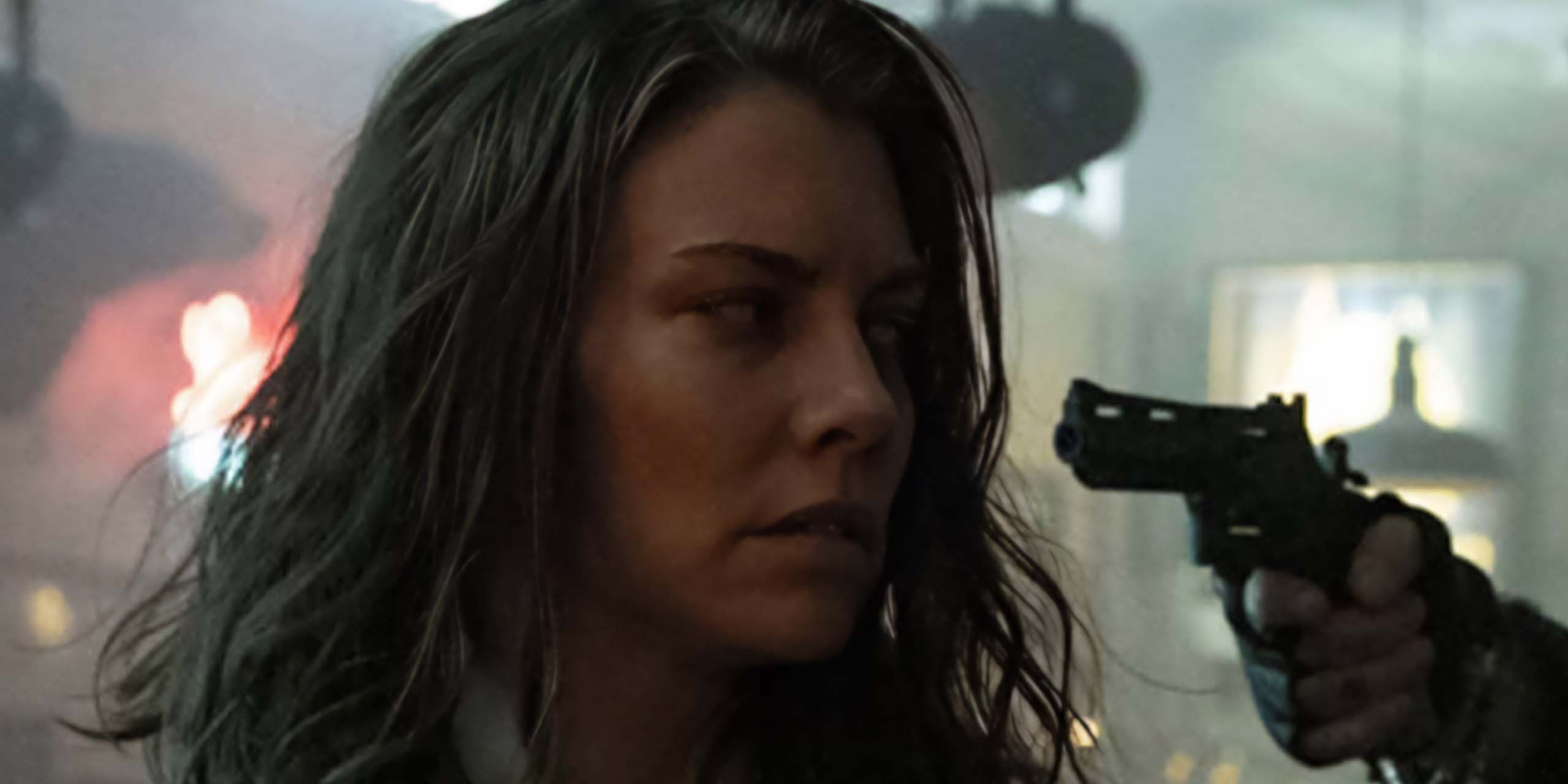 Maggie (Lauren Cohan) menacée par un revolver tenu par Negan (Jeffrey Dean Morgan) dans un bar de The Walking Dead: Dead City.