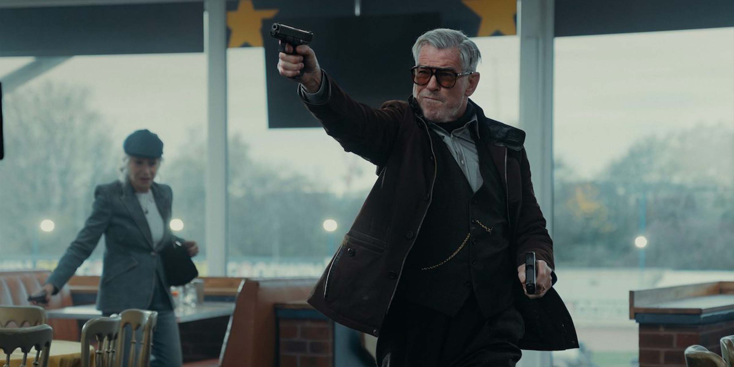 Conrad Harrigan (Pierce Brosnan) tire des coups de feu dans un restaurant dans la saison 2 de MobLand.