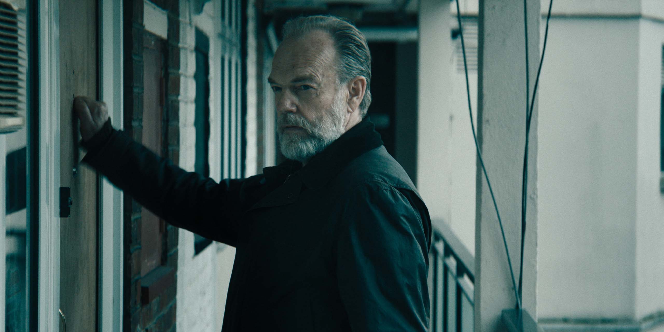 Frank Harkness (Hugo Weaving) frappant à la porte dans la saison 6 de Slow Horses.