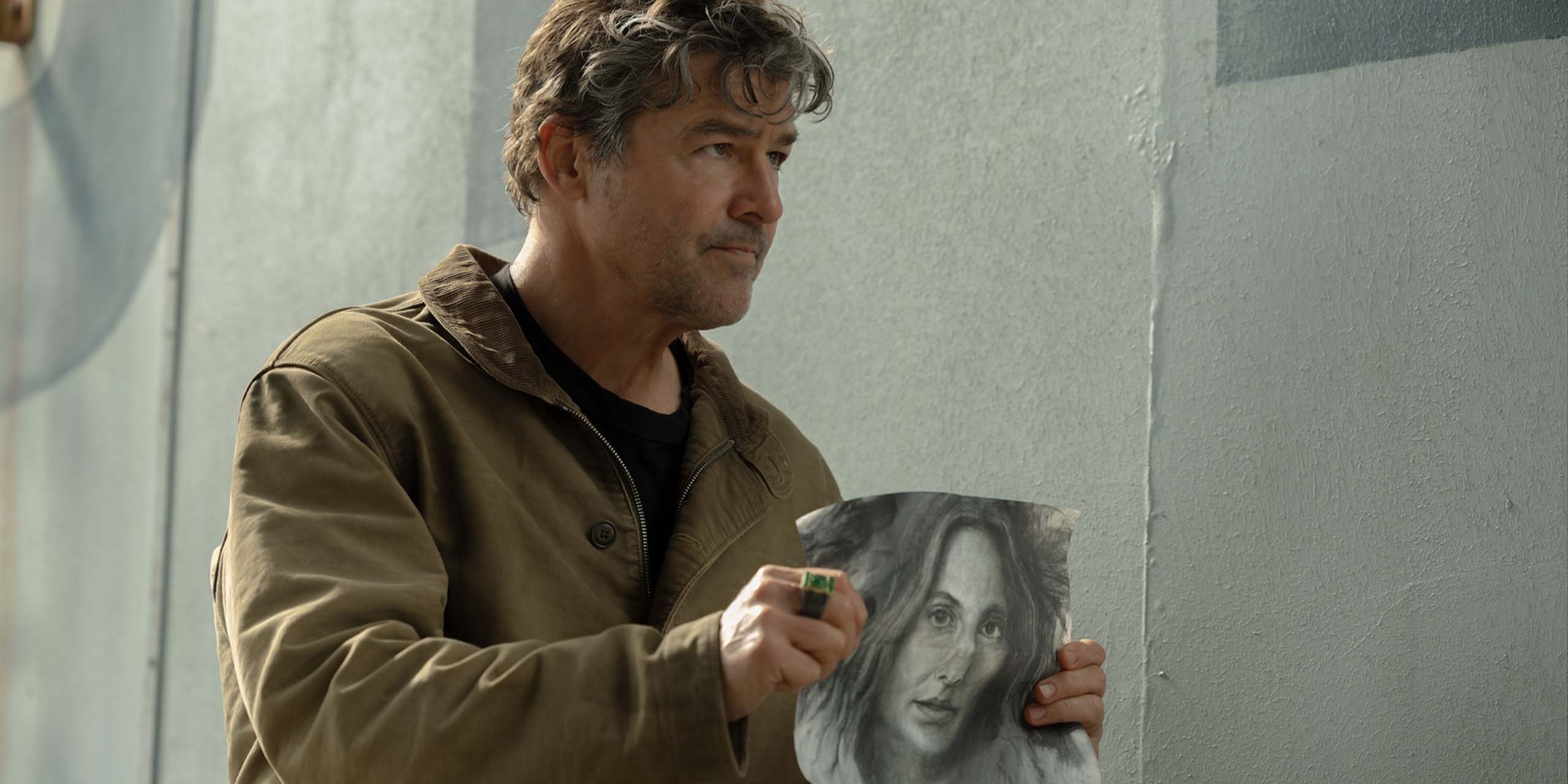 Hal Jordan (Kyle Chandler) tiens le portrait de Zoe dessiné par John dans Lanterns.