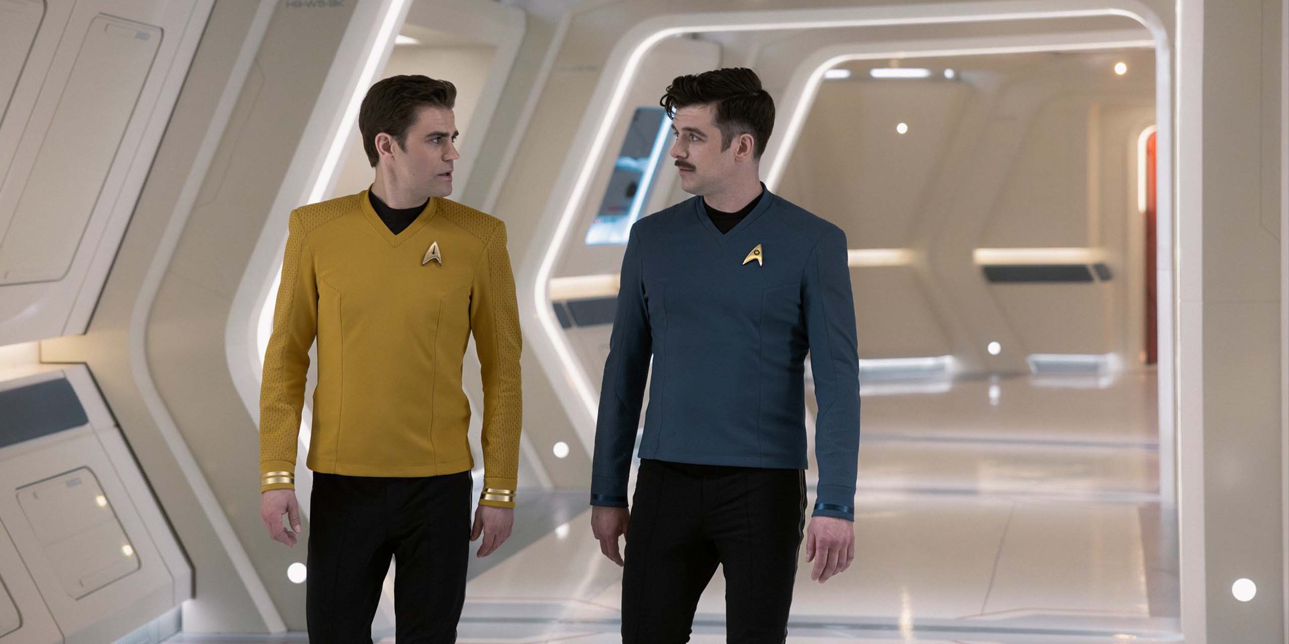 Paul Wesley (James T. Kirk) et Dan Jeannotte (Sam Kirk) marchent dans les couloirs de l'Entreprise dans la saison 4 de Star Trek: Strange New Worlds.