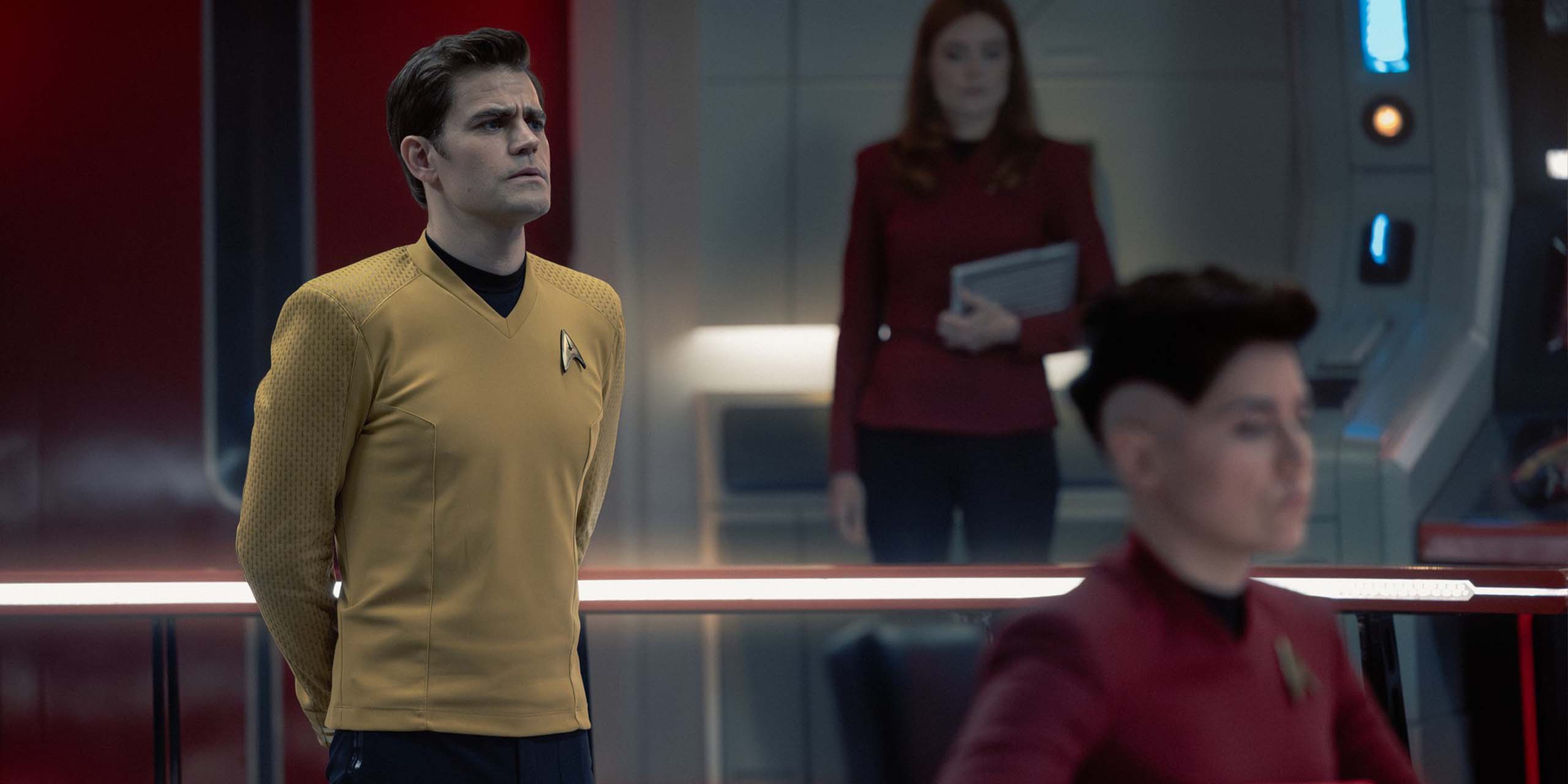 Paul Wesley (James T. Kirk) aux commandes de l'Entreprise, Ewa Wolniczek (Employee Vanek) et Melissa Navia (Erica Ortegas) dans la saison 4 de Star Trek: New Strange Worlds.