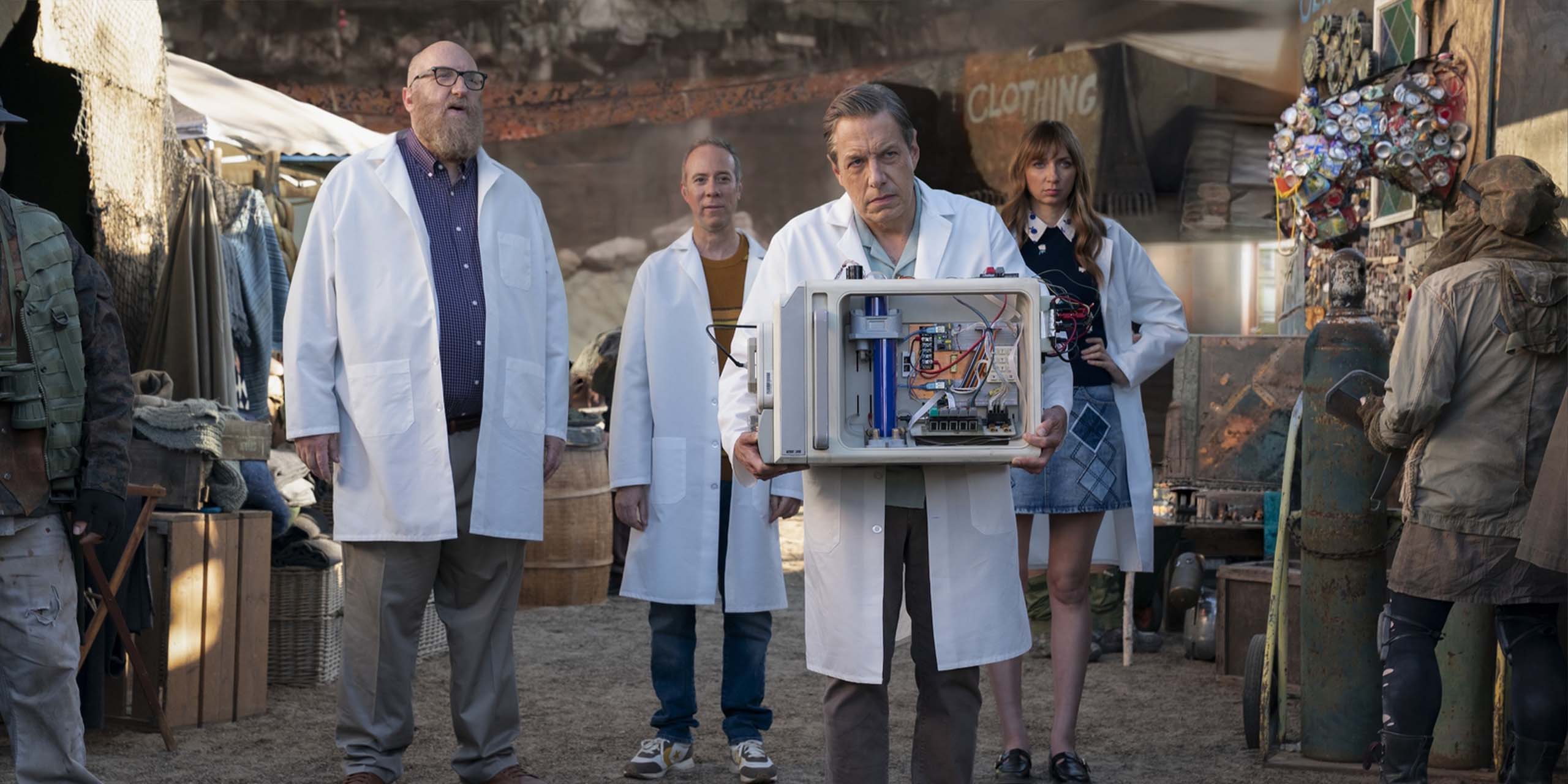 Barry, Denise, Stuart et Bert en blouse blanche tenant la machine dans Stuart fails to save the Universe.