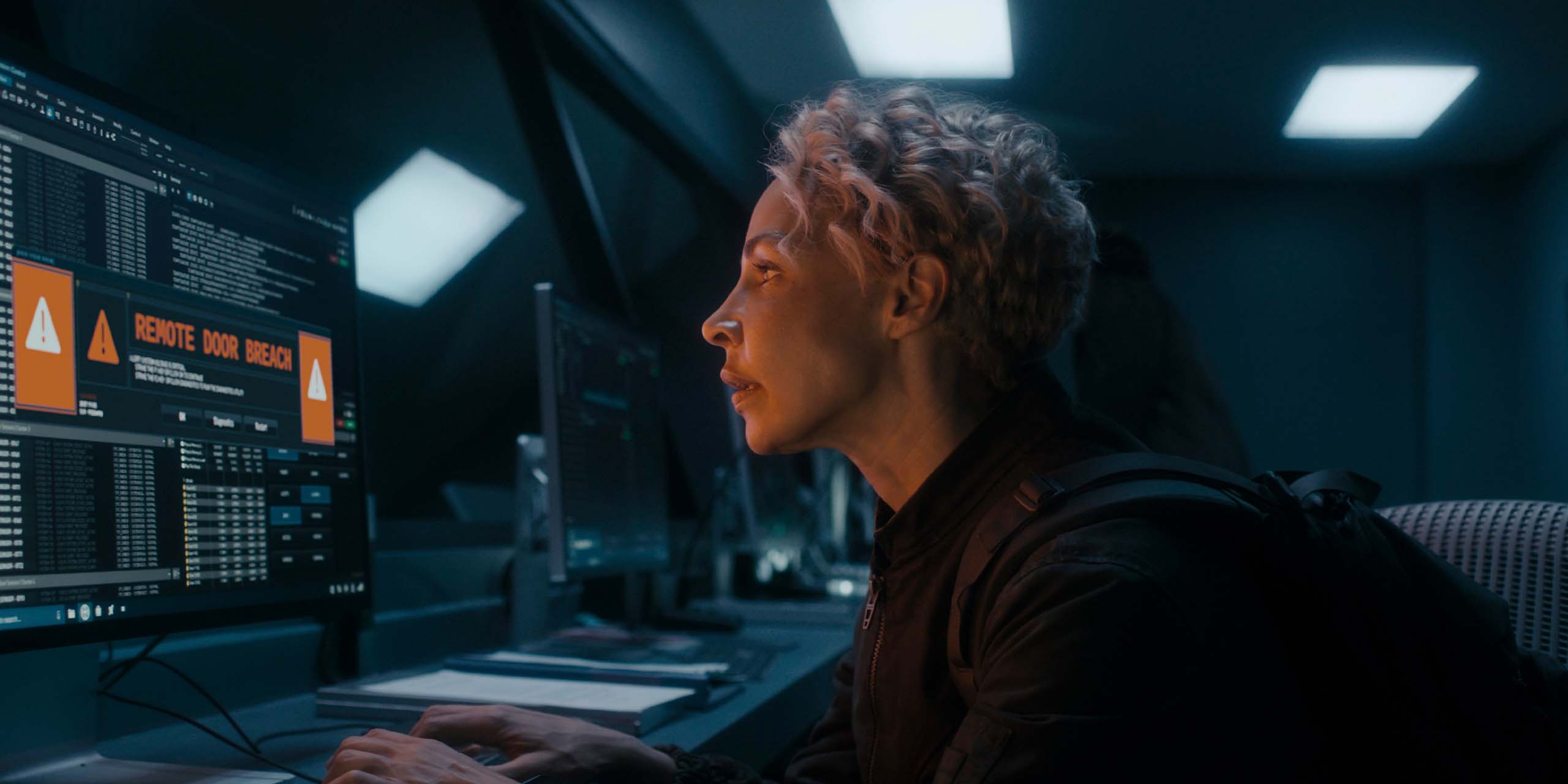 Blair Caplan (Amanda Brugel) devant un écran informatique dans la saison 2 de Dark Matter.