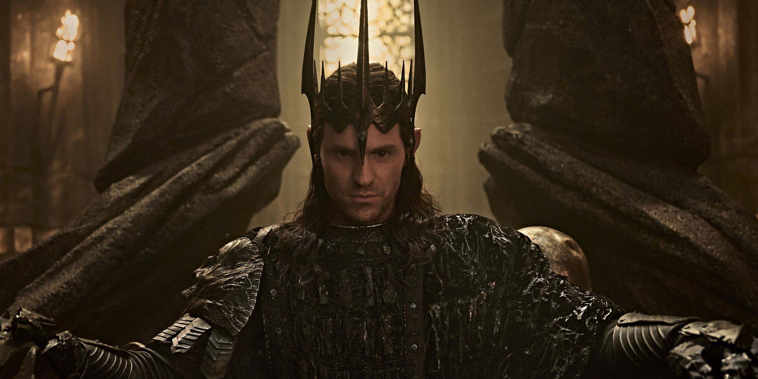 Charlie Vickers dans le rôle de Sauron, portant une couronne et assis sur un trône, dans la saison 3 du Seigneur des Anneaux : Les Anneaux du Pouvoir.