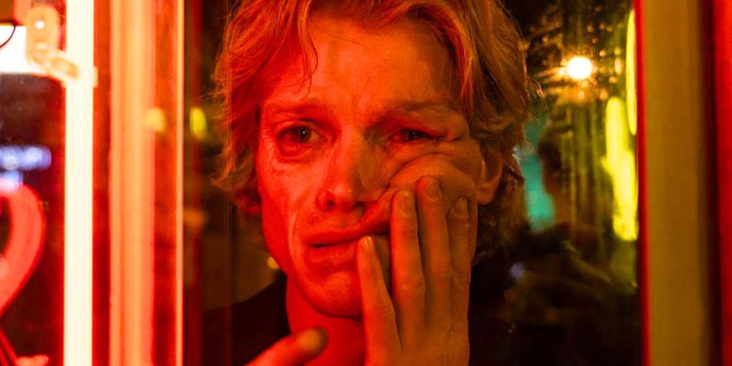 Hagen (Tom Rhys Harries) touche son visage coulant dans le film Clayface.