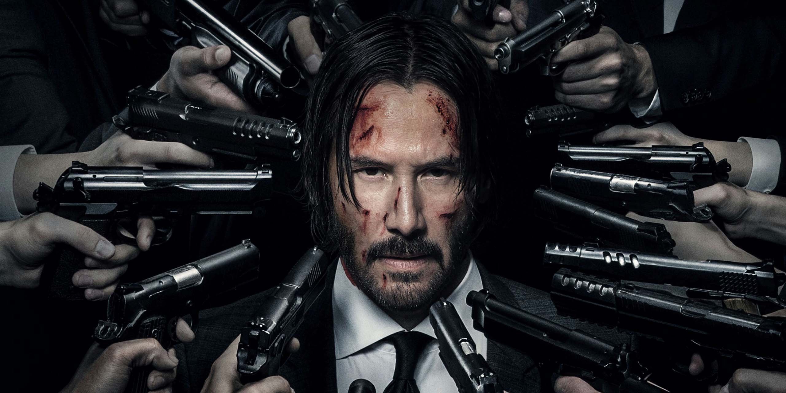 John Wick (Keanu Reeves) encerclé par de nombreuses armes à feu pointées vers lui.