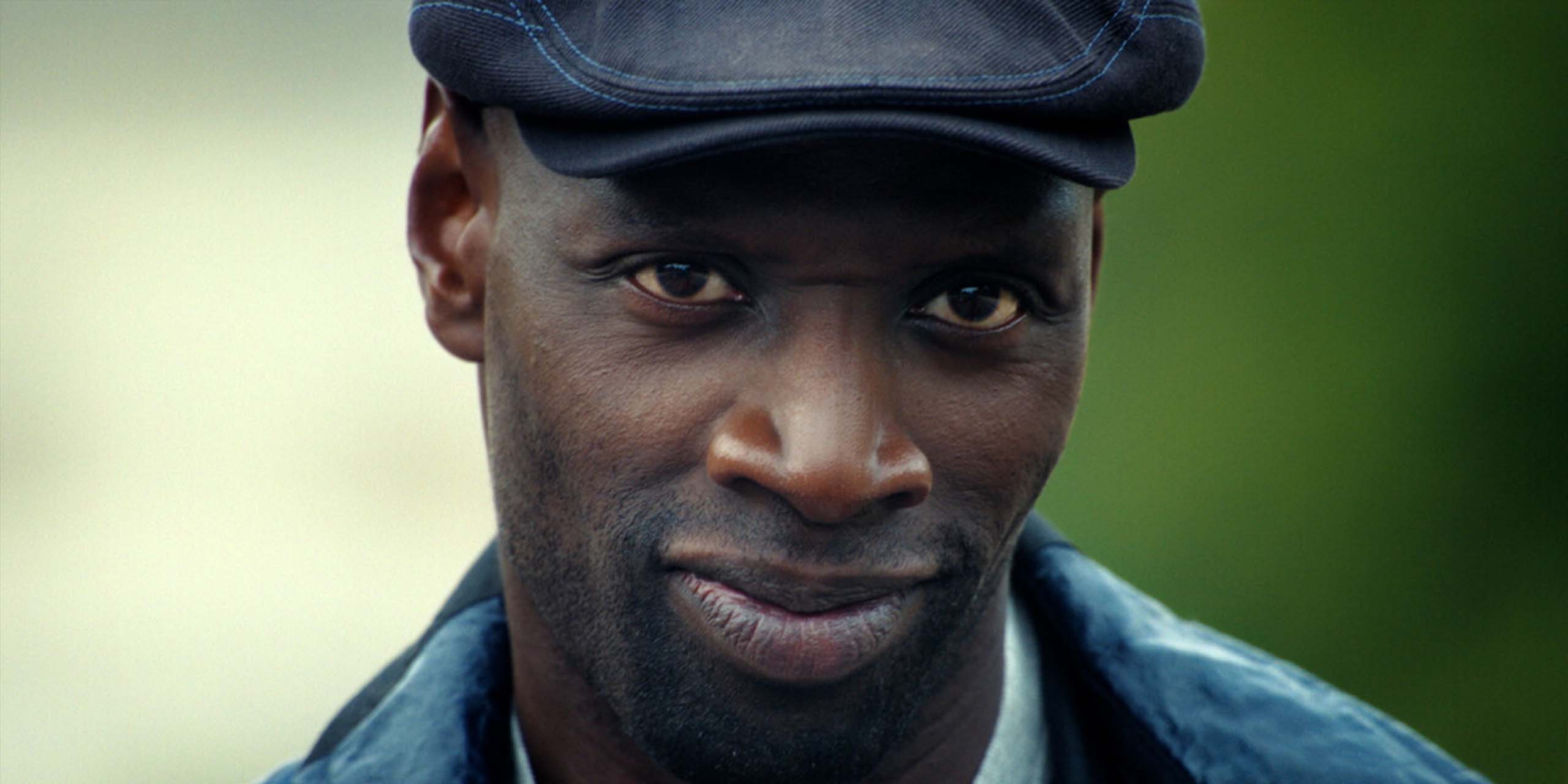 Assane (Omar Sy) souriant dans la saison 4 de Lupin.