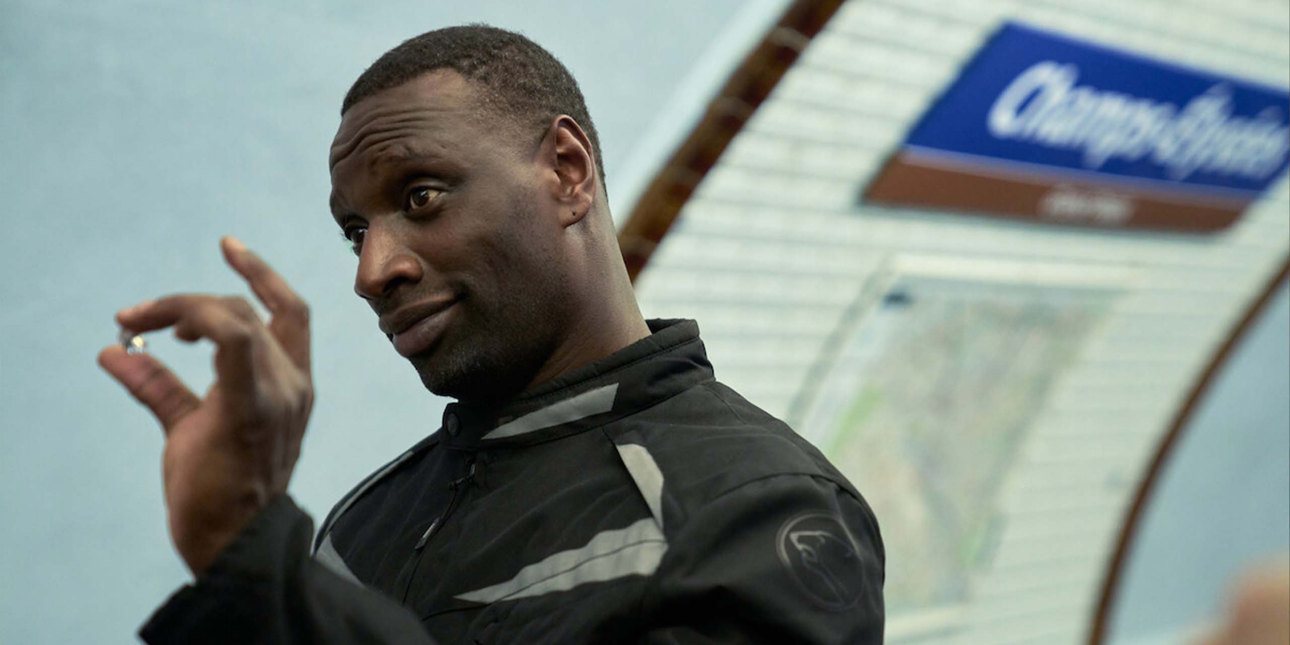 Assane (Omar Sy) tenant un bijou entre ses doigts dans une station de métro dans la saisons 4 de Lupin.