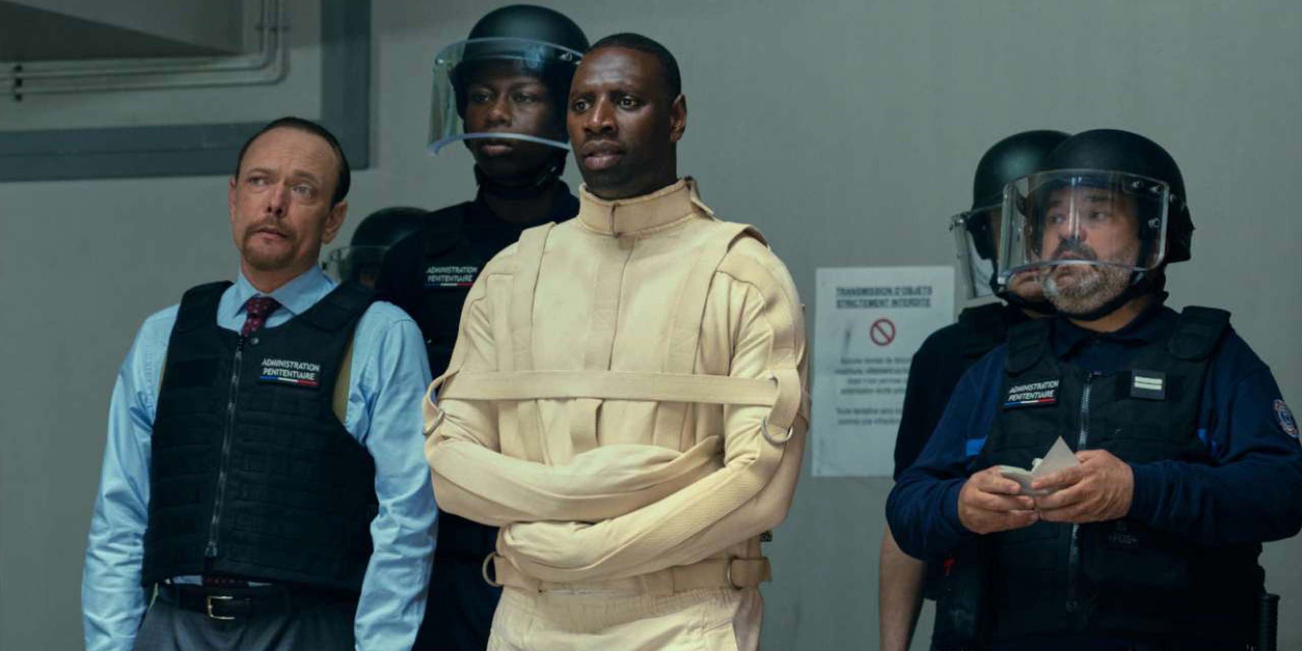 Assane (Omar Sy) dans une camisole de force, détenu par les agents de police, dans la saison 4 de Lupin.