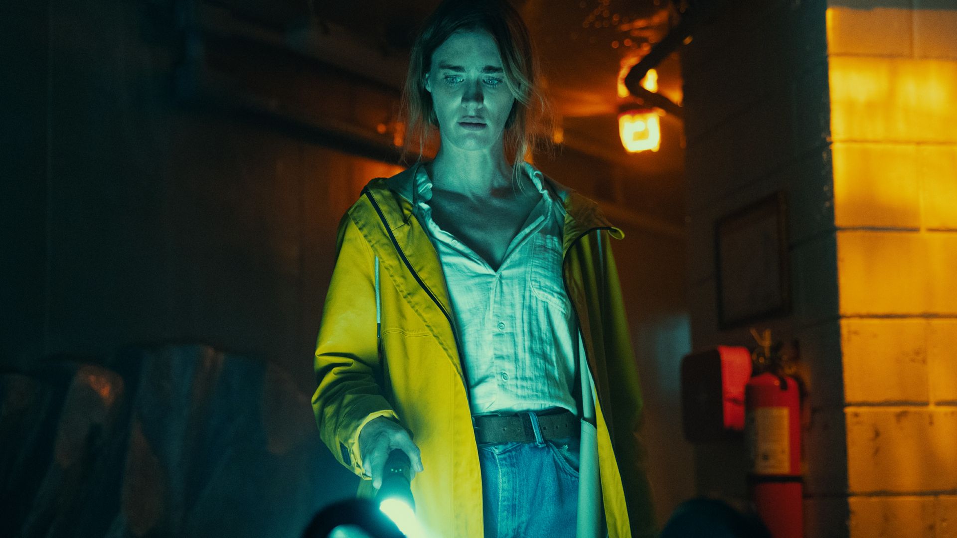 Mackenzie Davis dans le rôle de Fonda Howander, brandissant une lampe torche dans Below
