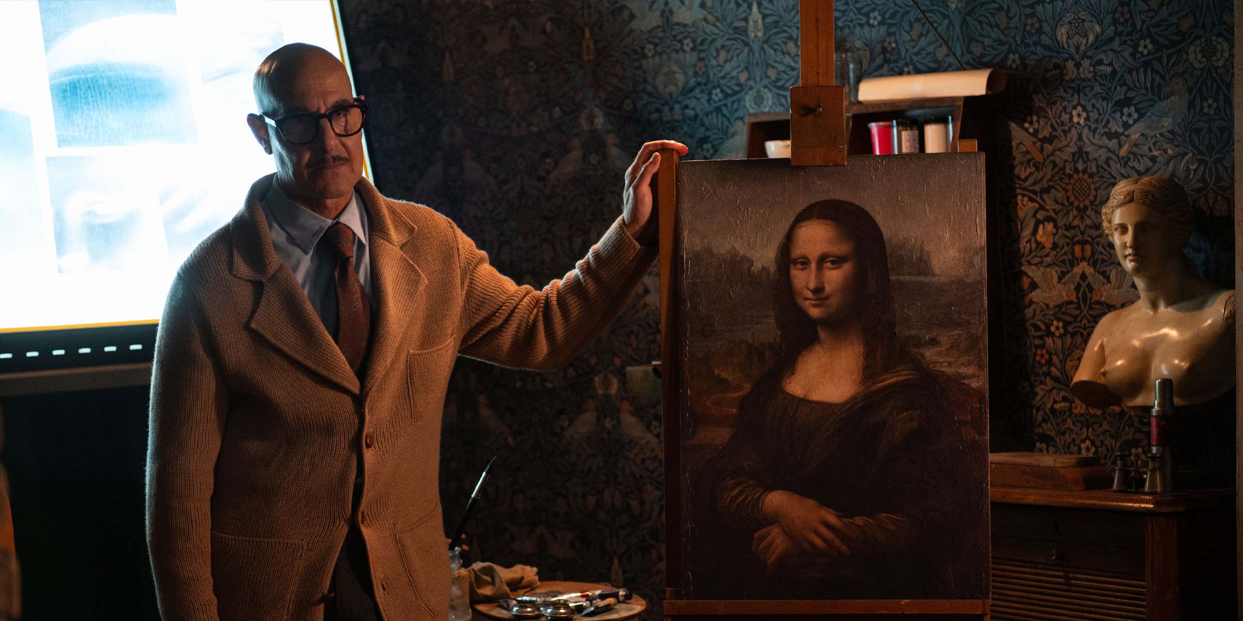 Roger Cavendish (Stanley Tucci) tenant le tableau de la Joconde dans Masterplan.