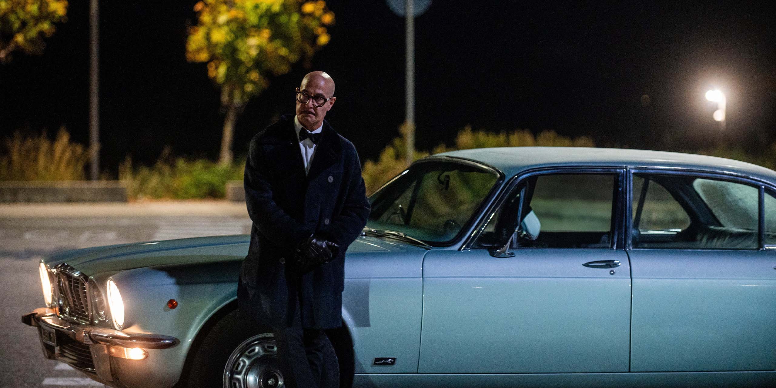 Roger Cavendish (Stanley Tucci) adoss&eacute; &agrave; une voiture dans Masterplan.
