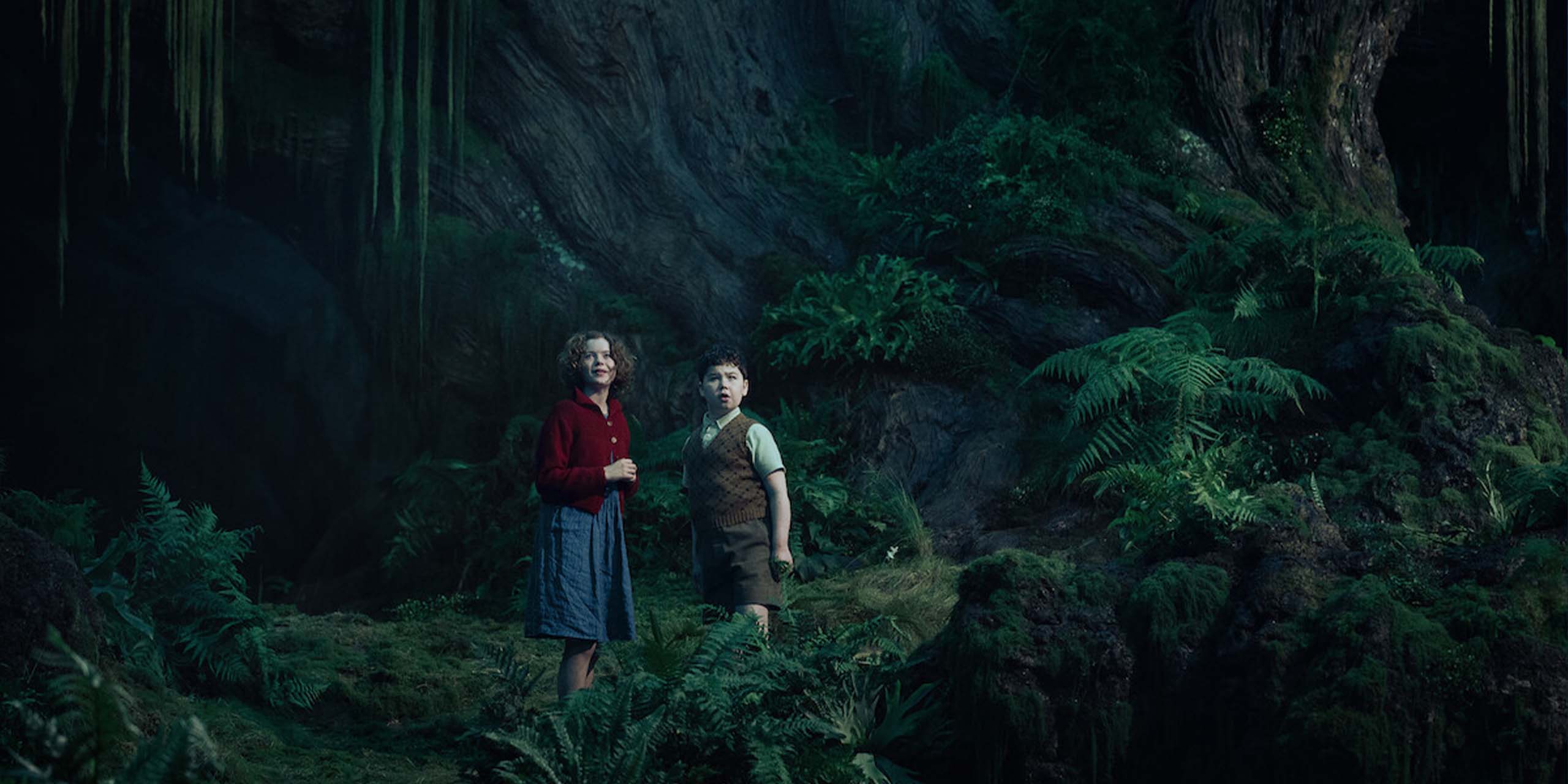 Polly se tient aux côtés de Digory dans le mystérieux Bois entre les mondes, dans Narnia : Le Neveu du magicien.